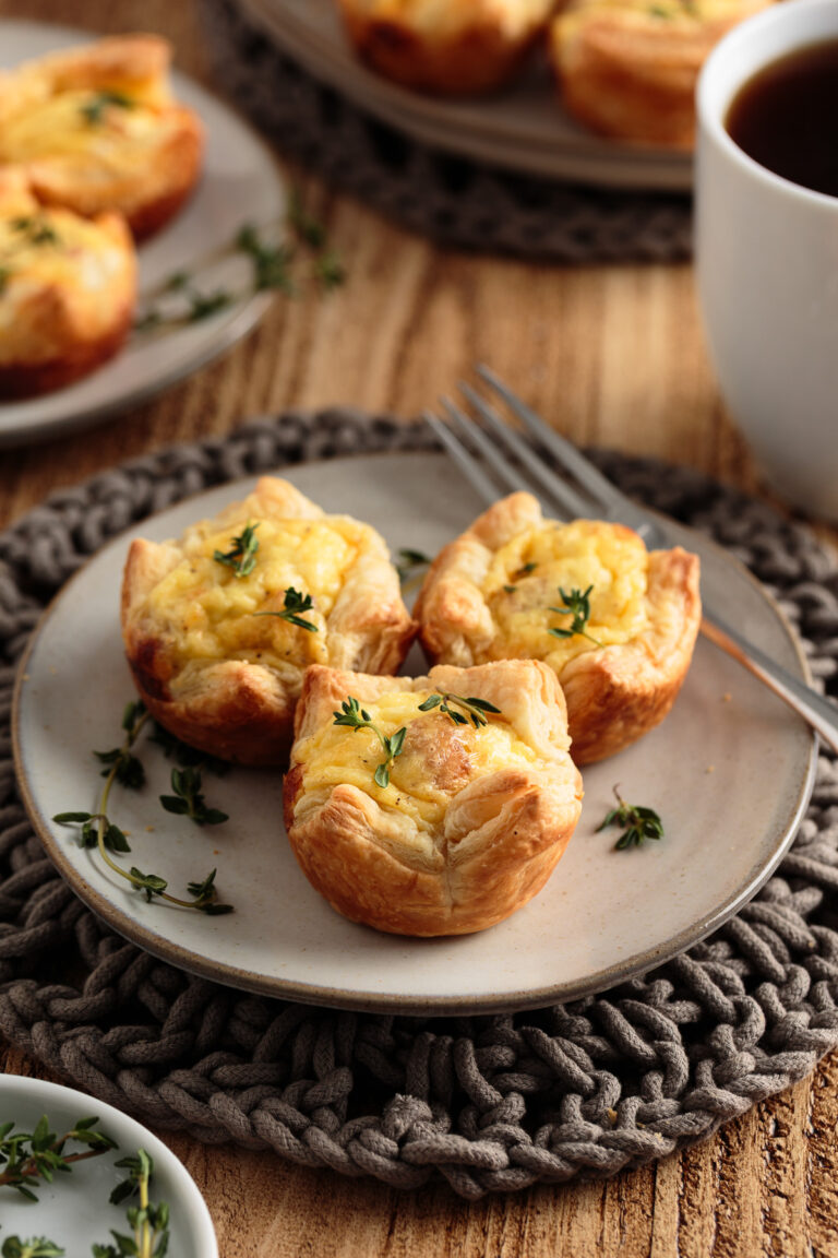 Plated mini quiches with puff pastry crusts.